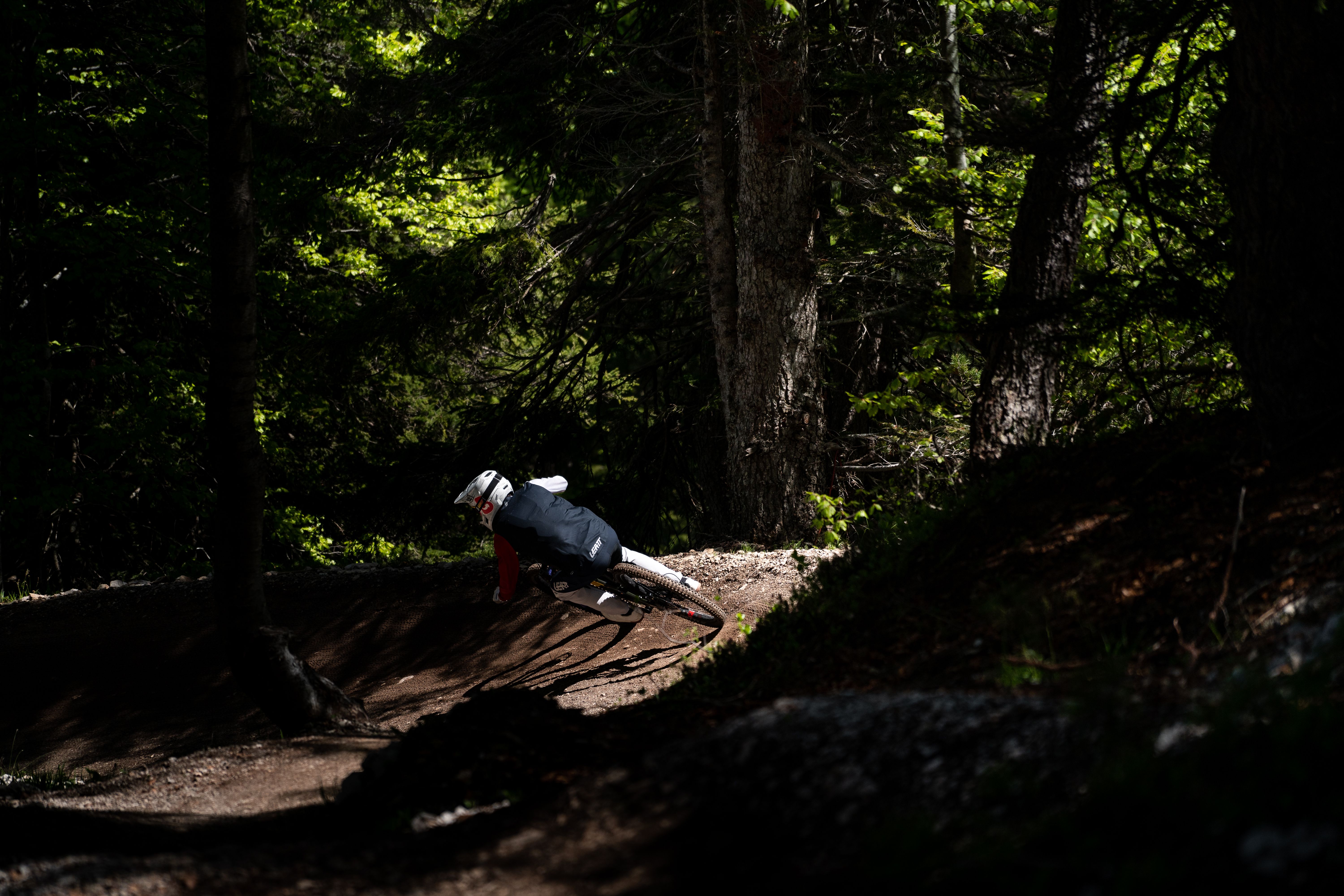 Rider descending a trail at Paganella Bike Park with the Dolomites in the background. Photo: Andrea Maranelli.